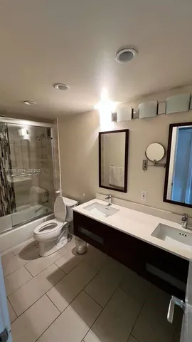 a bathroom with a double vanity sink a mirror and a bathtub