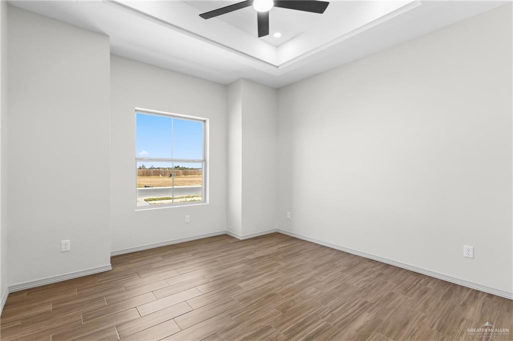 2102 Trinity Street Donna, TX 78537 - Photo 14 of 24 an empty room with wooden floor and windows
