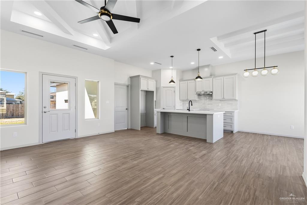 2102 Trinity Street Donna, TX 78537 - Photo 6 of 24 a large kitchen with white cabinets stainless steel appliances and wooden floor