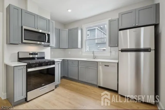 a kitchen with white cabinets and stainless steel appliances