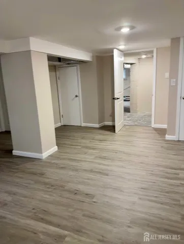 a view of empty room with wooden floor