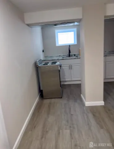 a room with a granite countertop cabinets and window