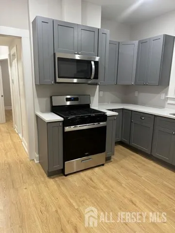 a kitchen with stainless steel appliances granite countertop a stove and a microwave