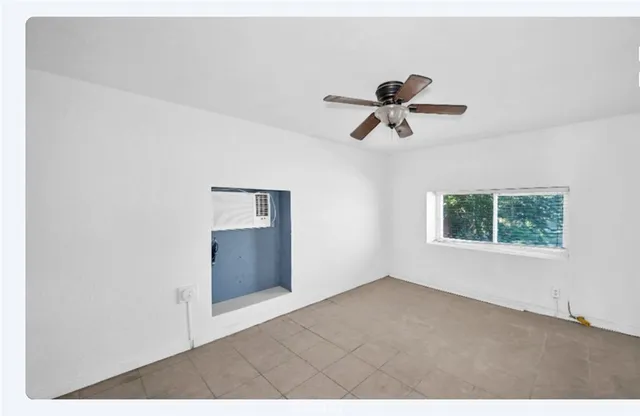a view of room with hardwood floor and a ceiling fan