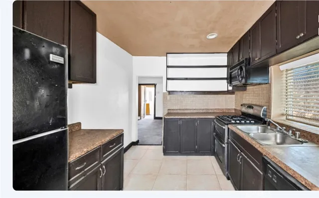 a kitchen with a sink stove top oven and cabinets