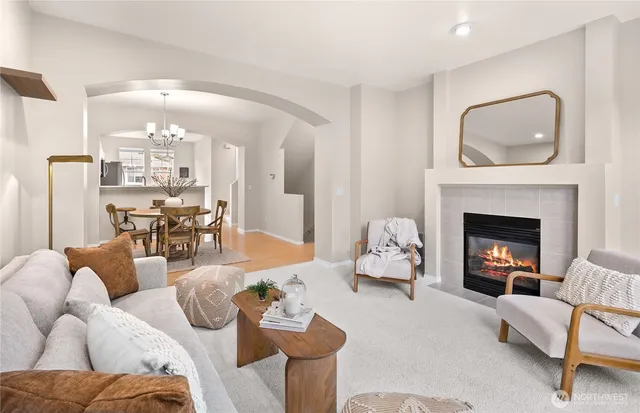 a living room with furniture a fireplace and a chandelier
