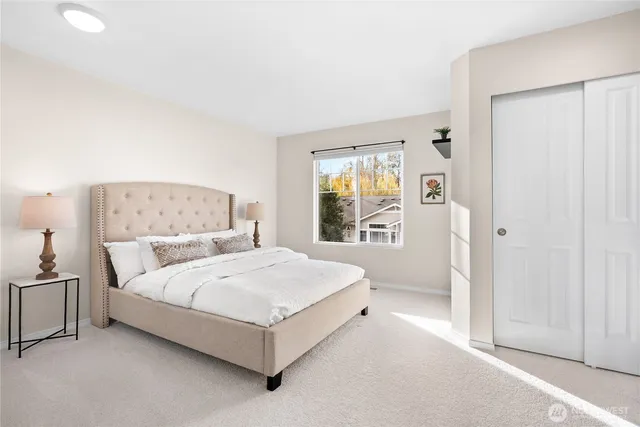 a bedroom with a bed lamp and a window