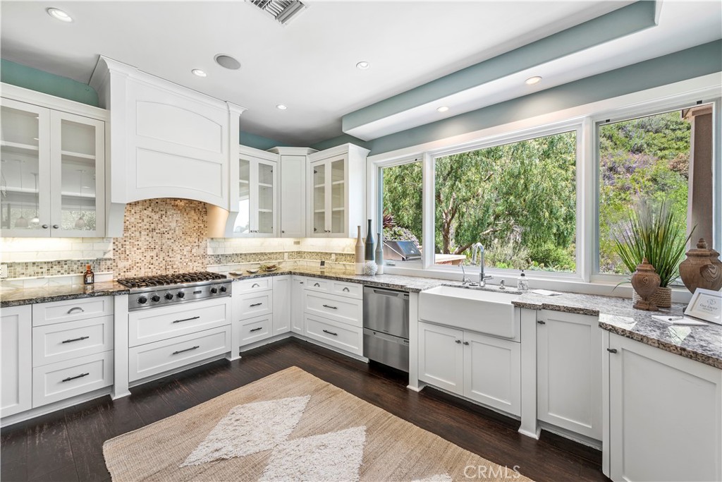 1339 Dunning Drive Laguna Beach, CA 92651 - Photo 22 of 42 a kitchen with granite countertop white cabinets white appliances a sink and a large window