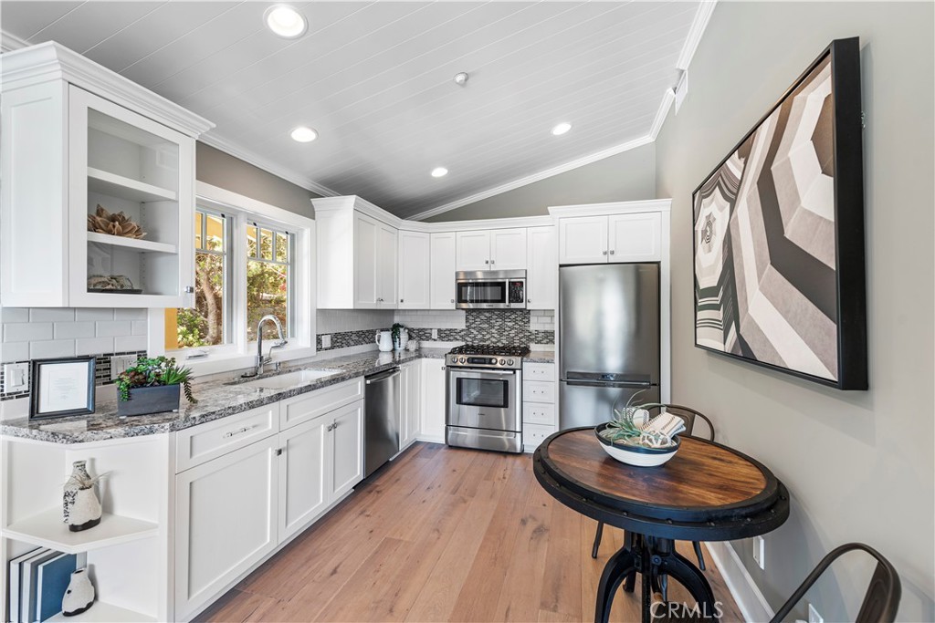 1339 Dunning Drive Laguna Beach, CA 92651 - Photo 40 of 42 a kitchen with stainless steel appliances kitchen island granite countertop a table chairs sink and cabinets