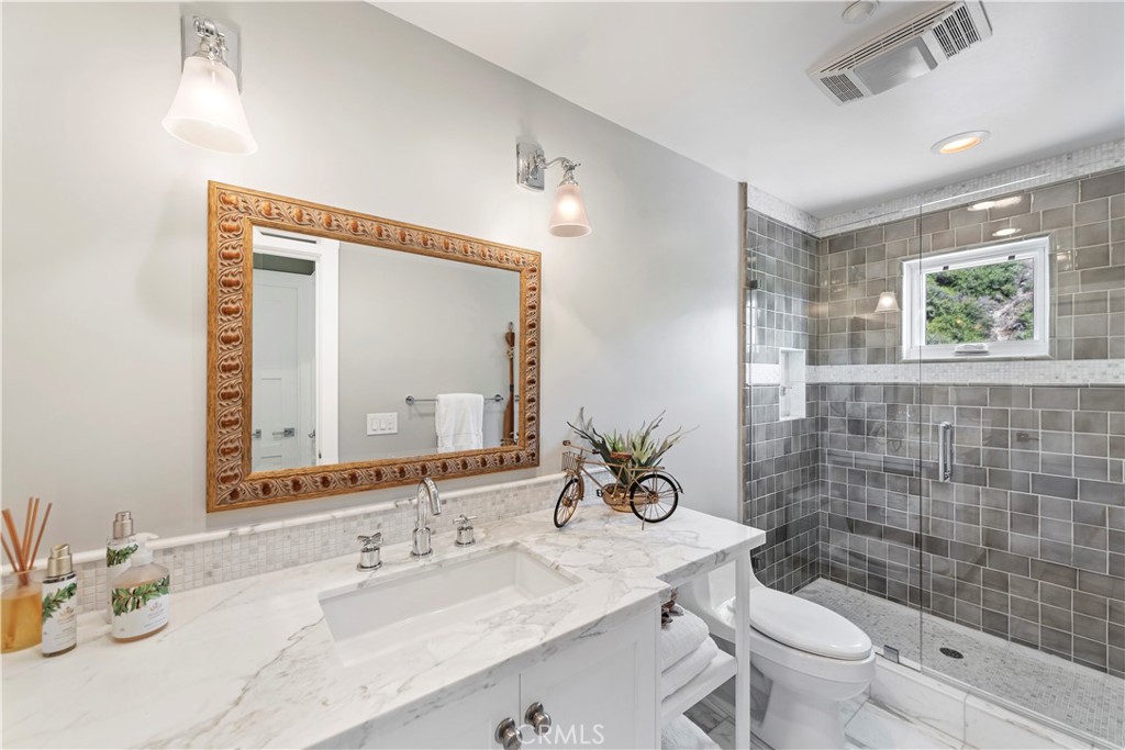 1339 Dunning Drive Laguna Beach, CA 92651 - Photo 42 of 42 a bathroom with a granite countertop sink a toilet a mirror and shower