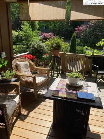 a view of a roof deck with table and chairs potted plants