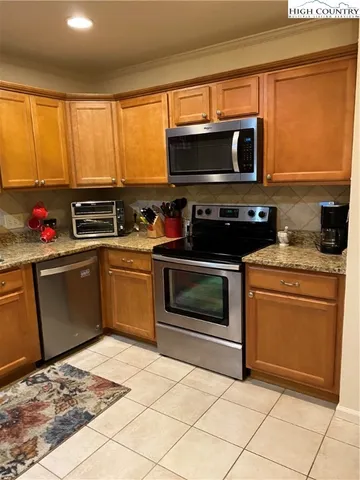 a kitchen with granite countertop a stove top oven microwave and cabinets