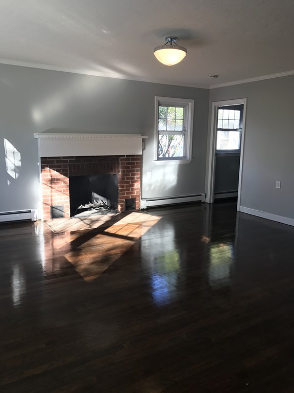20 Selwyn Road Randolph, MA 02368 - Photo 2 of 20 a view of empty room with wooden floor and fireplace
