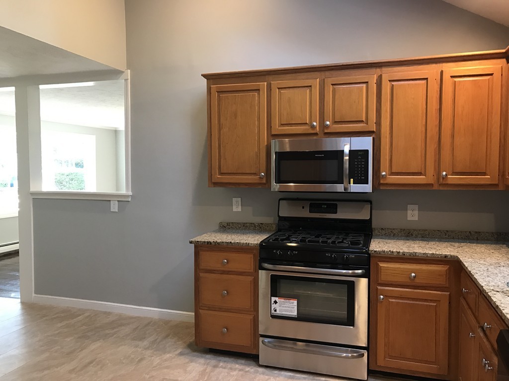 20 Selwyn Road Randolph, MA 02368 - Photo 6 of 20 a kitchen with granite countertop a stove and a microwave oven