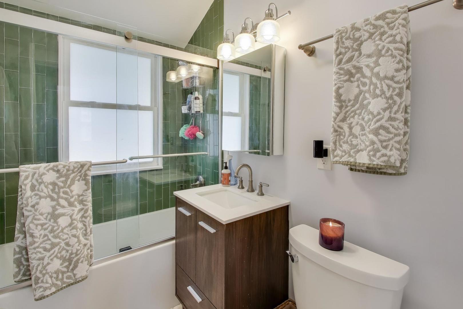 207 5th Street Wilmette, IL 60091 - Photo 28 of 30 a bathroom with a bathtub sink vanity mirror and tub