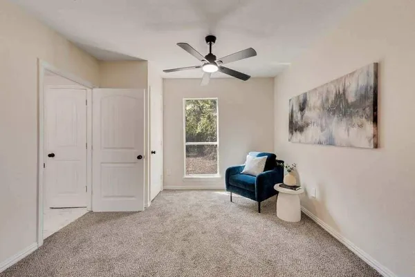 a living room with furniture and a ceiling fan