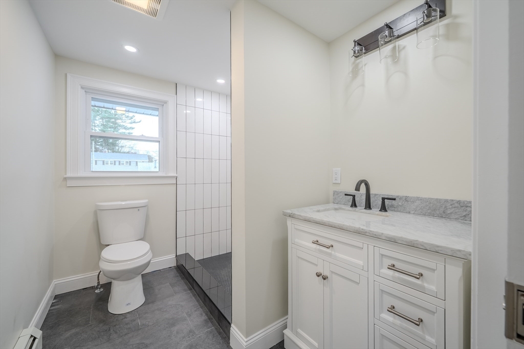 52 Bridge Street Billerica, MA 01821 - Photo 17 of 41 a bathroom with a granite countertop sink a toilet and a mirror