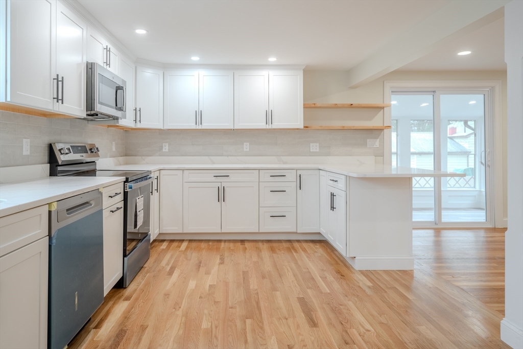52 Bridge Street Billerica, MA 01821 - Photo 3 of 41 a kitchen with wooden floors appliances and cabinets