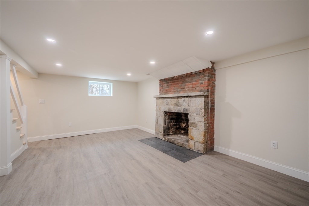 52 Bridge Street Billerica, MA 01821 - Photo 32 of 41 an empty room with wooden floor a fireplace and windows