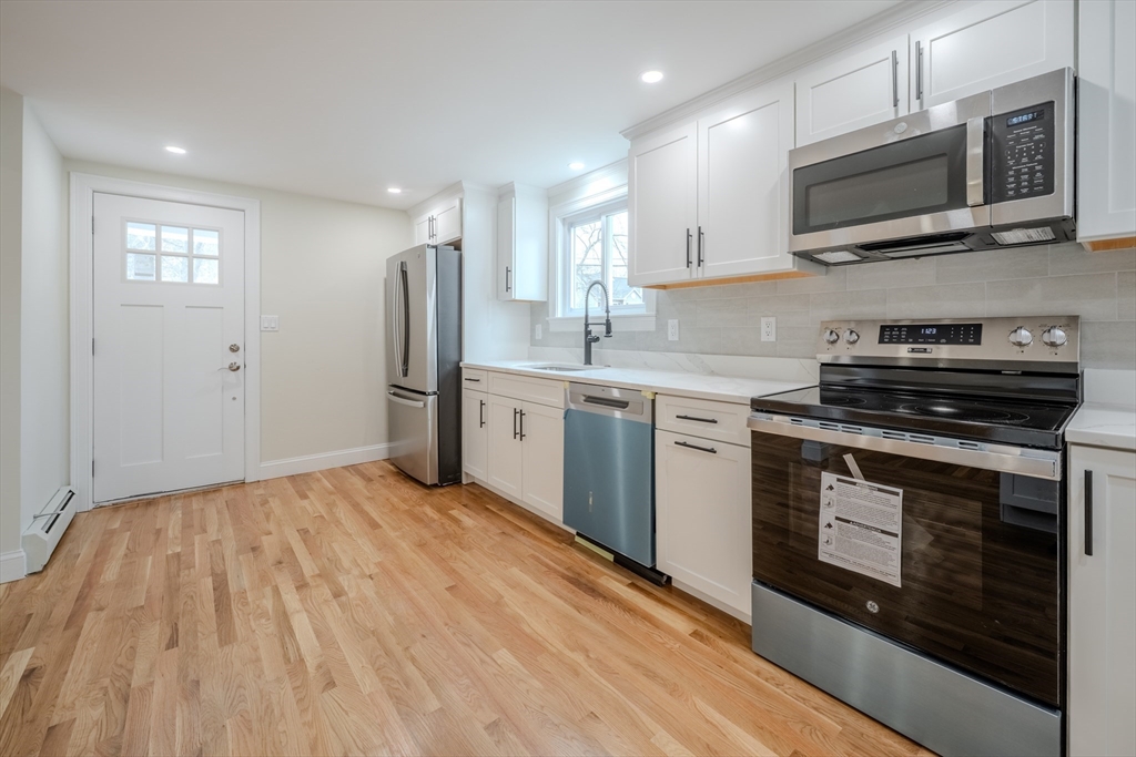 52 Bridge Street Billerica, MA 01821 - Photo 4 of 41 a kitchen with stainless steel appliances granite countertop a stove top oven a sink dishwasher a refrigerator and cabinets with wooden floor