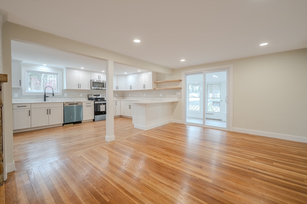 52 Bridge Street Billerica, MA 01821 - Photo 7 of 41 a large kitchen with a wooden floor and stainless steel appliances