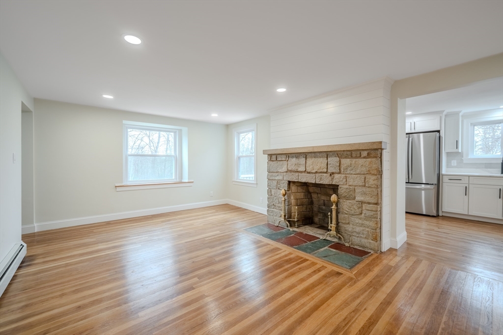 52 Bridge Street Billerica, MA 01821 - Photo 9 of 41 an empty room with wooden floor fireplace and windows