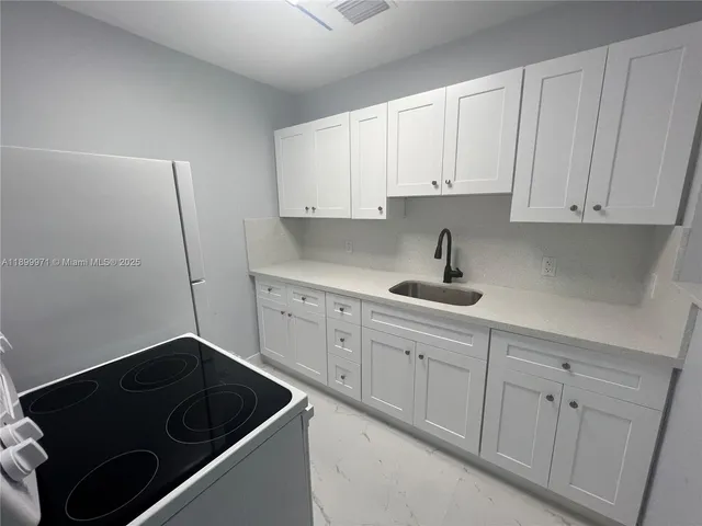 a kitchen with white cabinets and a sink