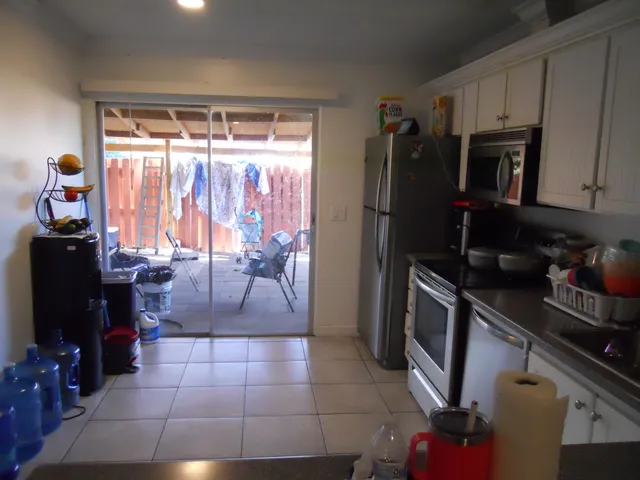 a kitchen with stainless steel appliances granite countertop a refrigerator stove and white cabinets