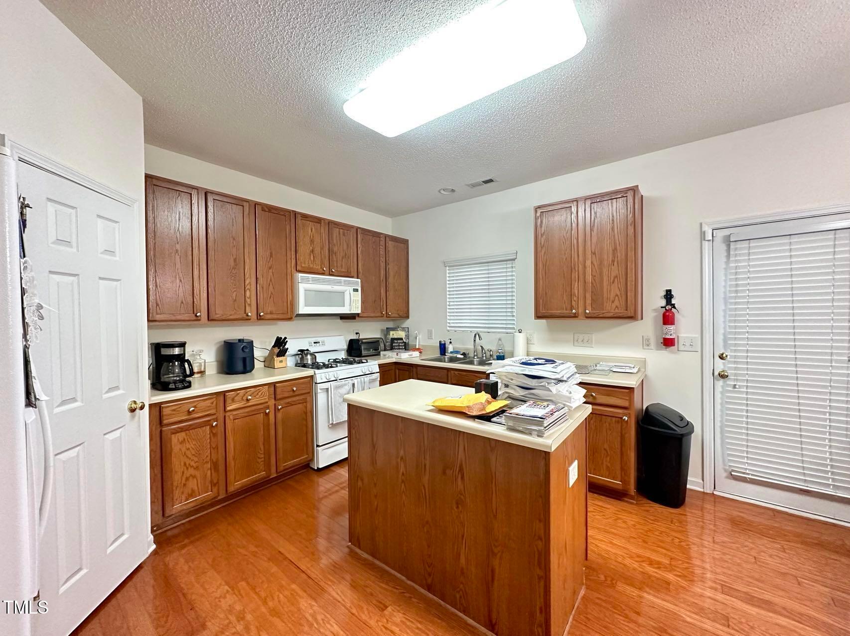 114 Graystar Road Apex, NC 27502 - Photo 6 of 14 a kitchen with stainless steel appliances granite countertop wooden cabinets sink stove and refrigerator