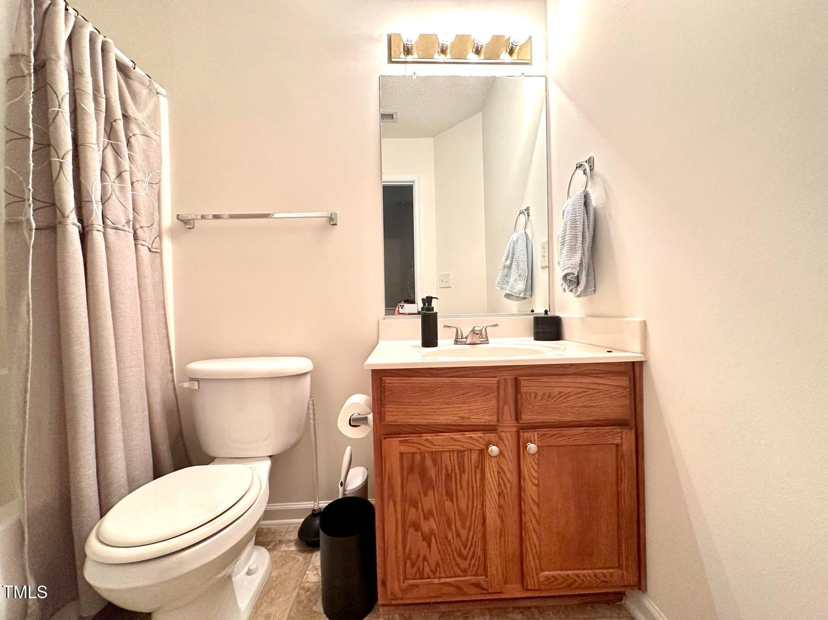 114 Graystar Road Apex, NC 27502 - Photo 10 of 14 a bathroom with a sink vanity mirror and toilet