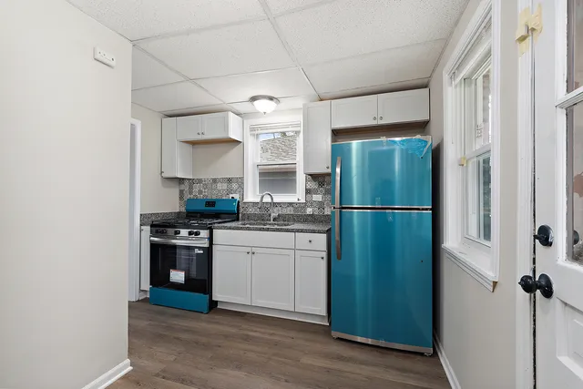 a kitchen with granite countertop a refrigerator and a sink