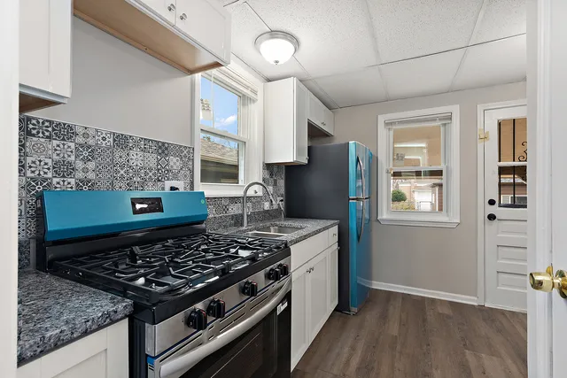 a kitchen with stainless steel appliances granite countertop a stove a refrigerator and a oven