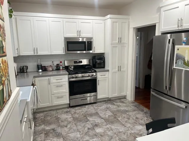 a kitchen with stainless steel appliances granite countertop a refrigerator stove and sink
