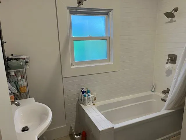 a bathroom with a tub sink and mirror