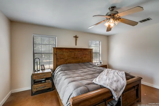 a bedroom with a bed and a ceiling fan