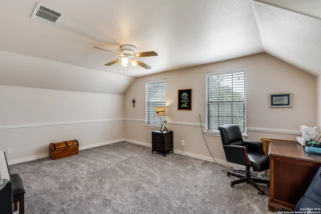 a view of a workspace with furniture and a window
