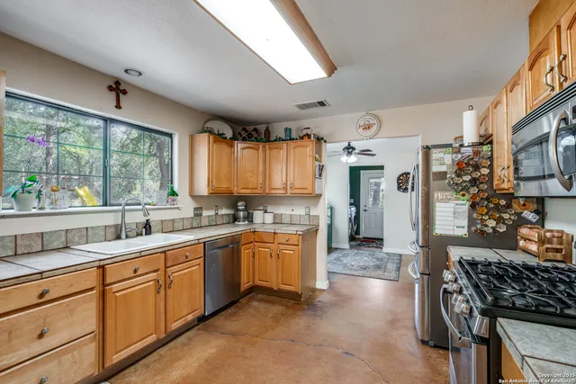 a large kitchen with stainless steel appliances granite countertop a stove and a sink