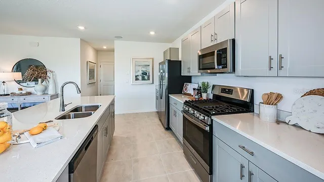 a view of kitchen with refrigerator stove dining table and chairs