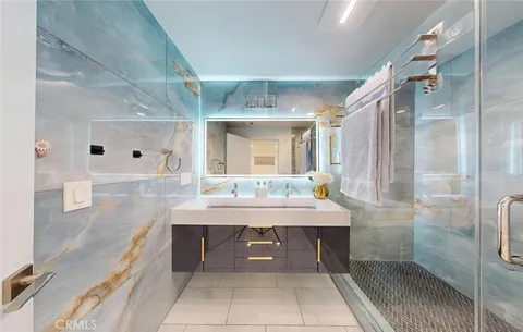 a large white kitchen with stainless steel appliances granite countertop a couch and cabinets