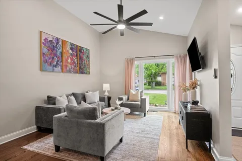 a living room with furniture a flat screen tv and a window