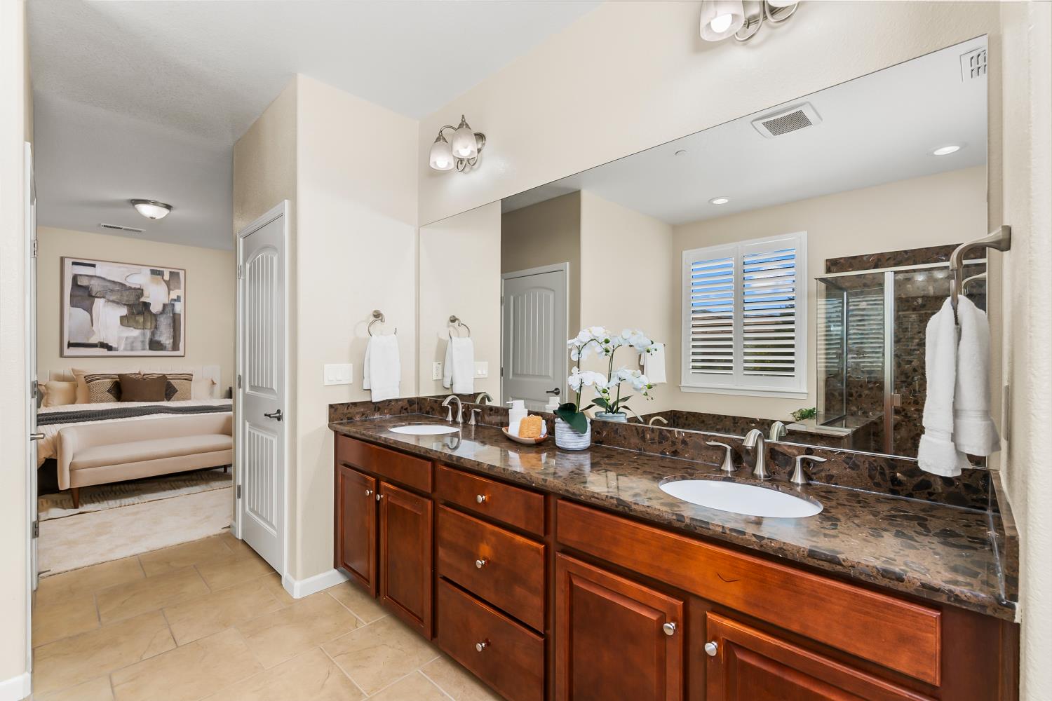 5453 Mossy Stone Way Rancho Cordova, CA 95742 - Photo 41 of 81 a bathroom with double vanity sinks a large mirror and a shower