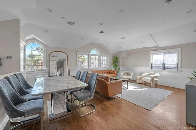 a living room with furniture a large window and wooden floor
