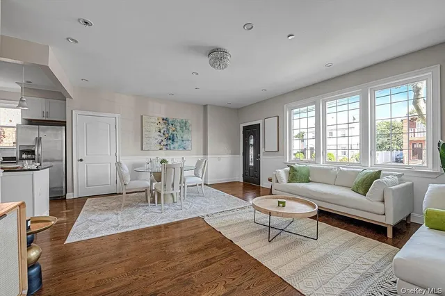 a living room with furniture a dining table and a large window