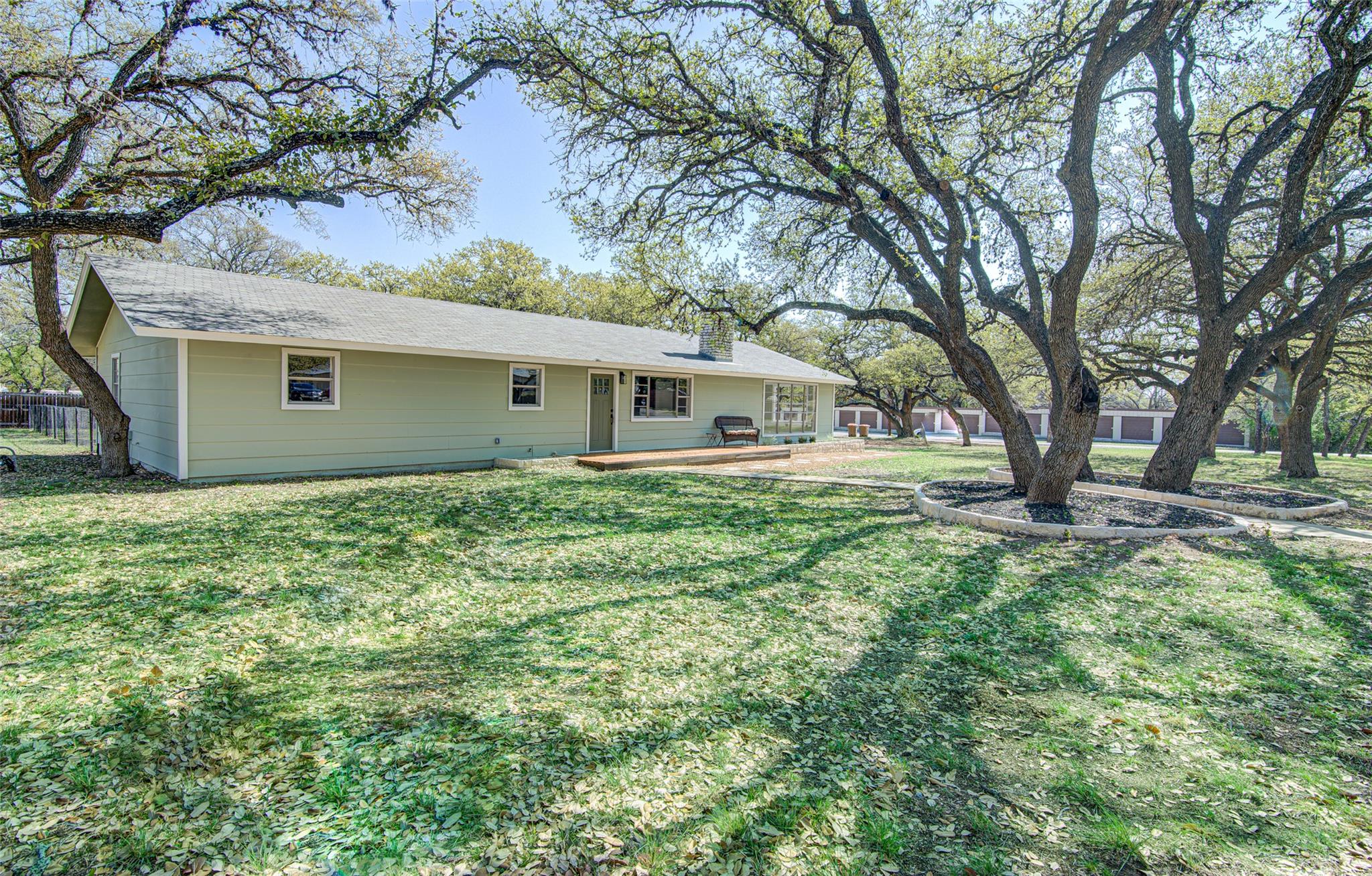 207 Haley Road Johnson City, TX 78636 - Photo 7 of 31 Mature trees shade this inviting residence, offering natural beauty and a sense of tranquility.