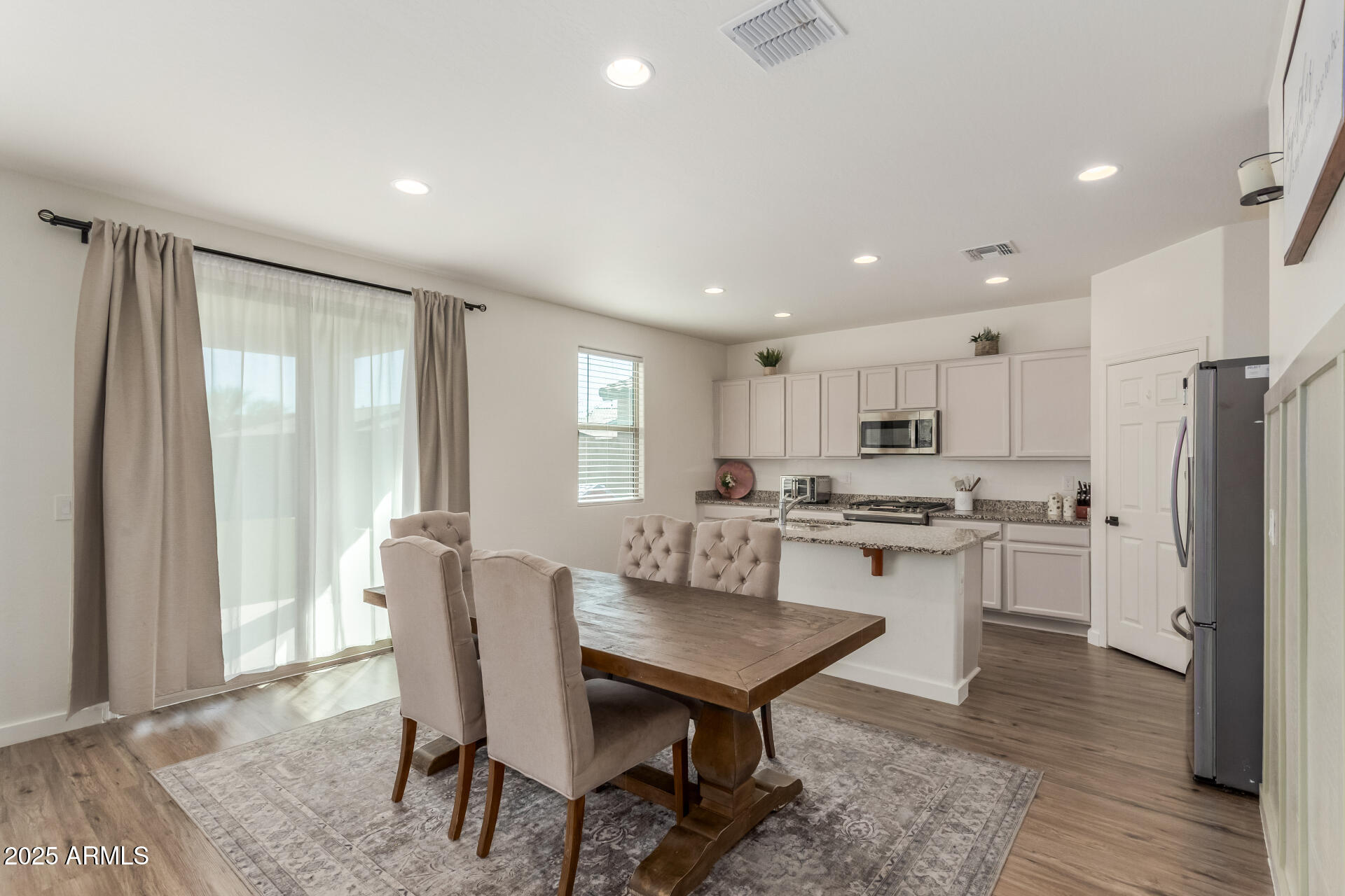3215 West Pollack Street Phoenix, AZ 85041 - Photo 5 of 26 a kitchen with refrigerator a table and chairs