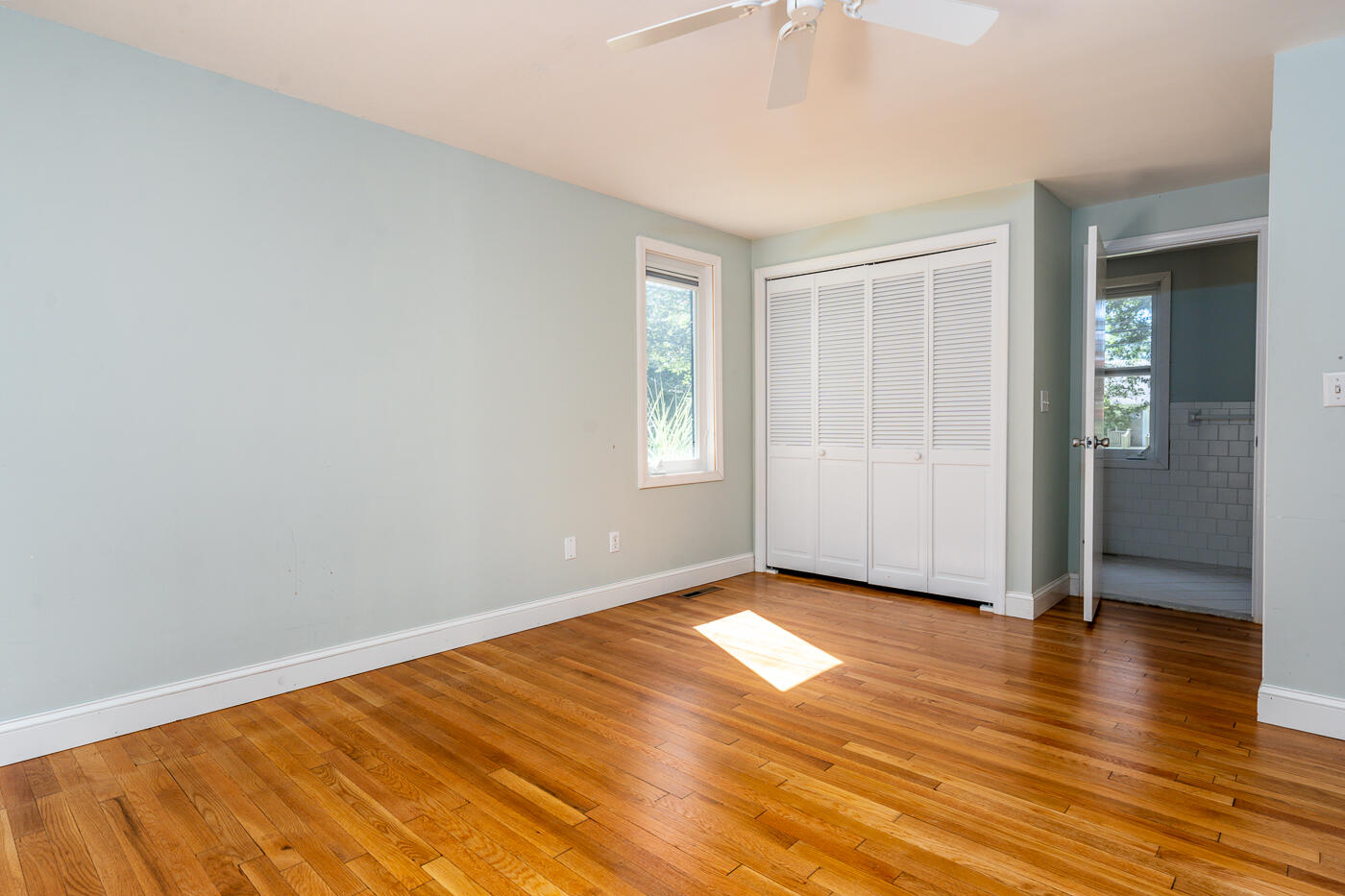 57 Holly Point Road Centerville, MA 02632 - Photo 14 of 41 an empty room with wooden floor and windows