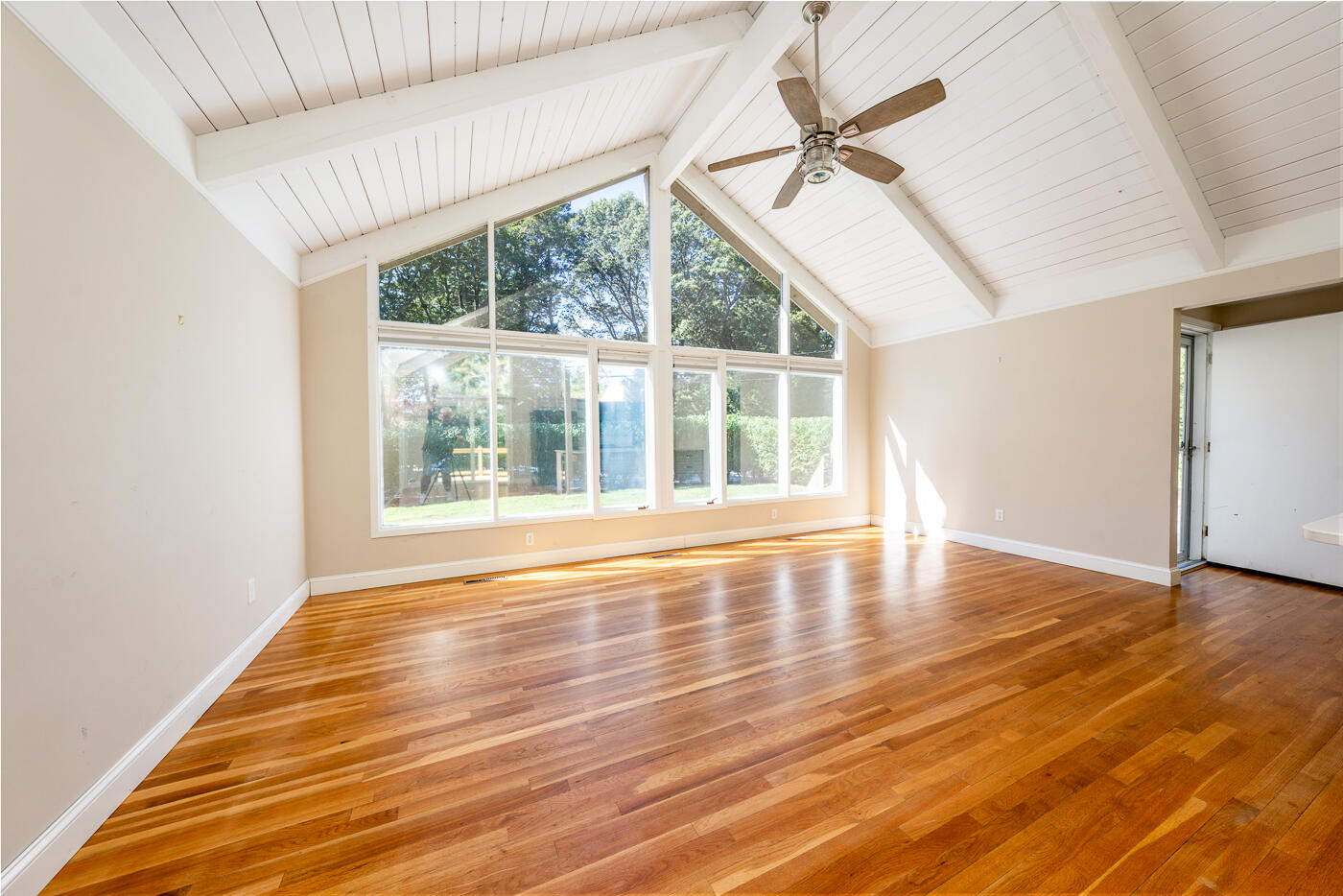 57 Holly Point Road Centerville, MA 02632 - Photo 3 of 41 an empty room with wooden floor and fan