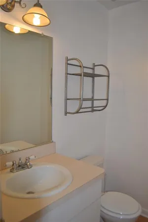 a bathroom with a sink a toilet and mirror