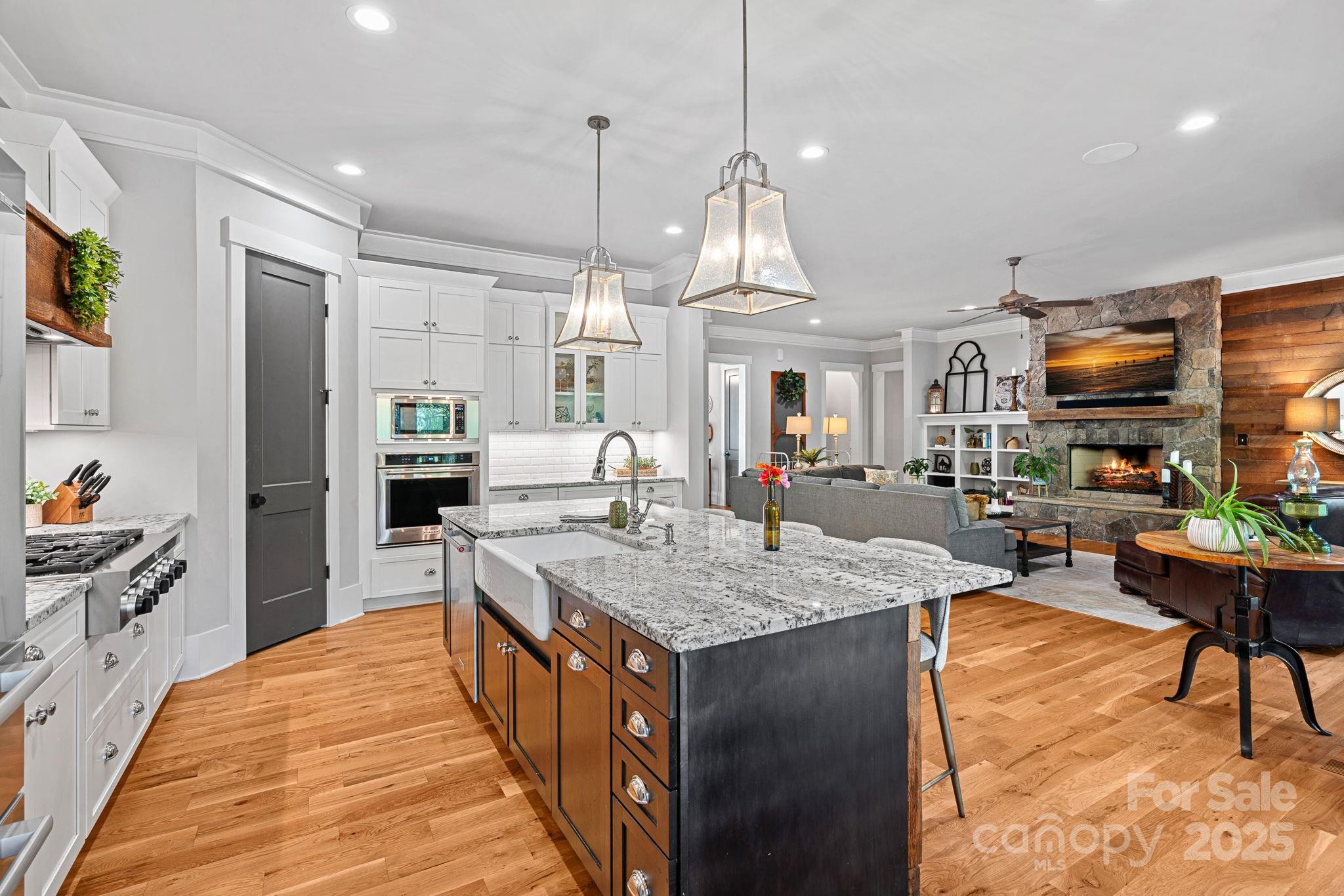 327 Kenway Loop Mooresville, NC 28117 - Photo 14 of 46 a large kitchen with kitchen island a large counter space a sink appliances and living room view