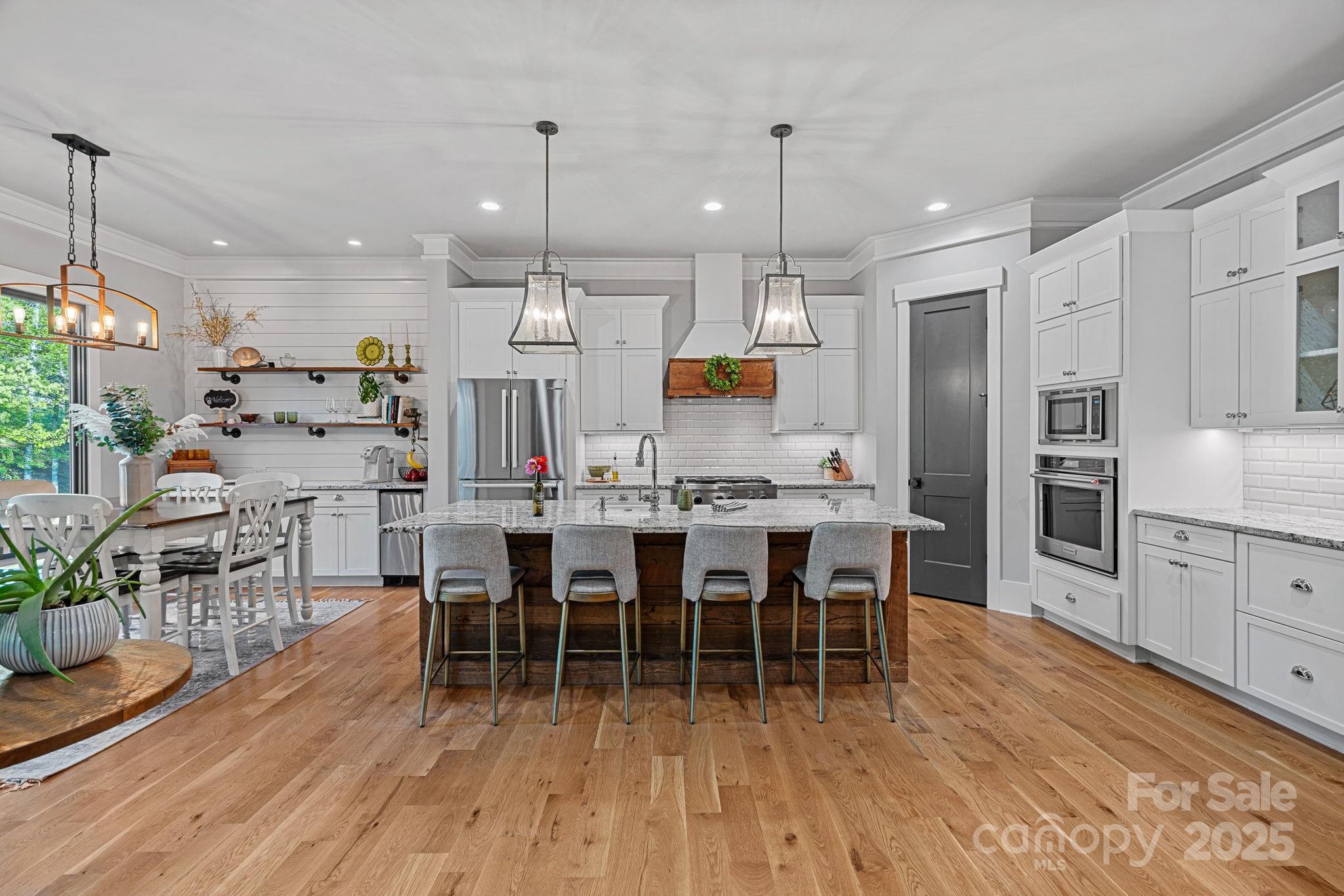327 Kenway Loop Mooresville, NC 28117 - Photo 10 of 46 a large kitchen with cabinets chairs and wooden floor